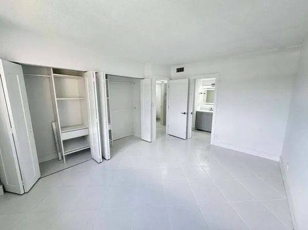 a view of empty room with closet and racks