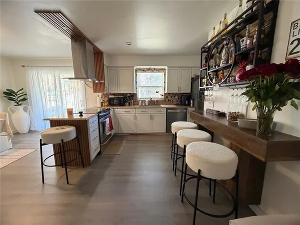 a kitchen with sink refrigerator dining table and chairs