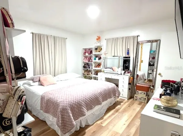 a bedroom with a bed a large window and book self
