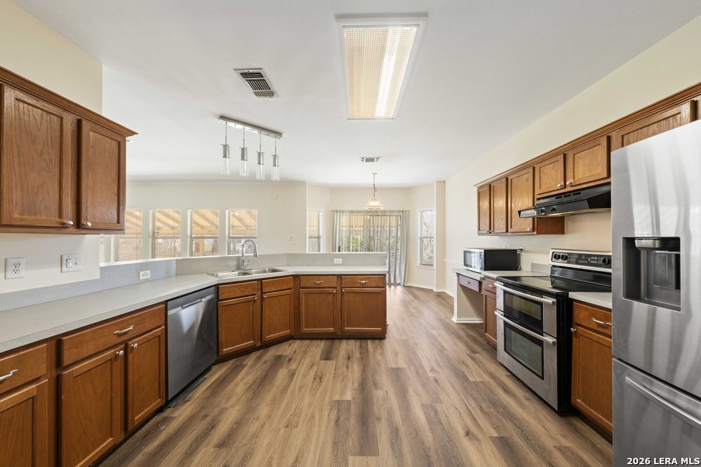 12319 Stable Rd Drive San Antonio, TX 78249 - Photo 14 of 34 a kitchen with stainless steel appliances granite countertop lots of counter top space a sink and cabinets