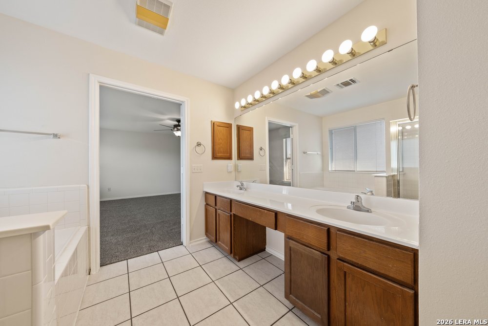 12319 Stable Rd Drive San Antonio, TX 78249 - Photo 27 of 34 a spacious bathroom with a sink a vanity and a mirror
