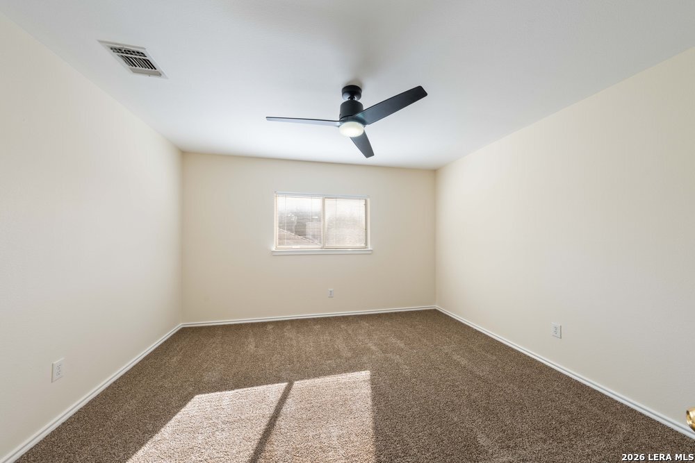12319 Stable Rd Drive San Antonio, TX 78249 - Photo 28 of 34 an empty room with a ceiling fan and window