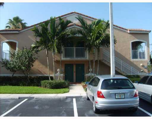 3870 Lyons Road, Unit 1018 Coconut Creek, FL 33073 - Photo 1 of 5 a white building covered with tall trees