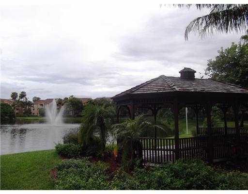 3870 Lyons Road, Unit 1018 Coconut Creek, FL 33073 - Photo 3 of 5 a view of house with garden and tall trees