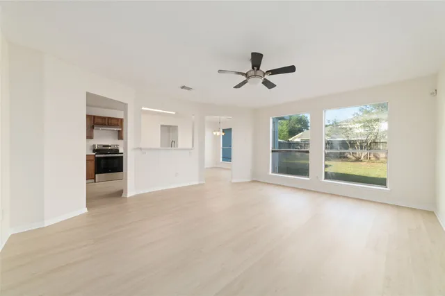 a view of empty room with wooden floor and windows
