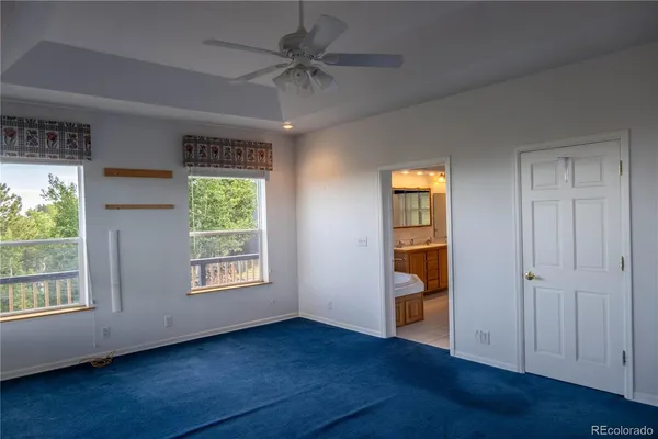 an empty room with wooden floor cabinet and windows