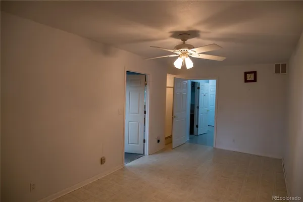 a view of a room with a ceiling fan and a fan
