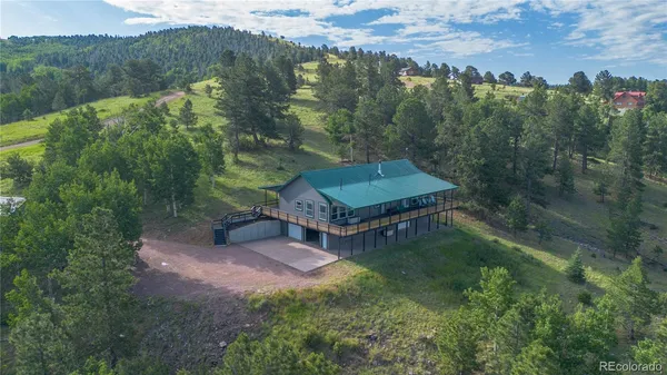 an aerial view of a house with yard and green space