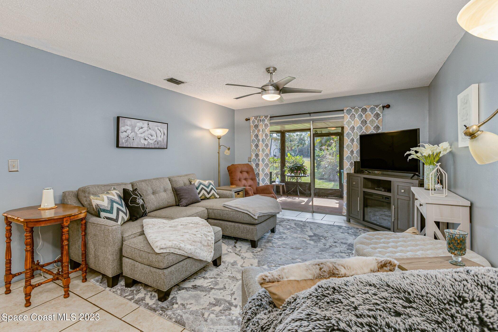 905 Prosperity Place, Unit 1902 Rockledge, FL 32955 - Photo 13 of 35 a living room with furniture a flat screen tv and a fireplace