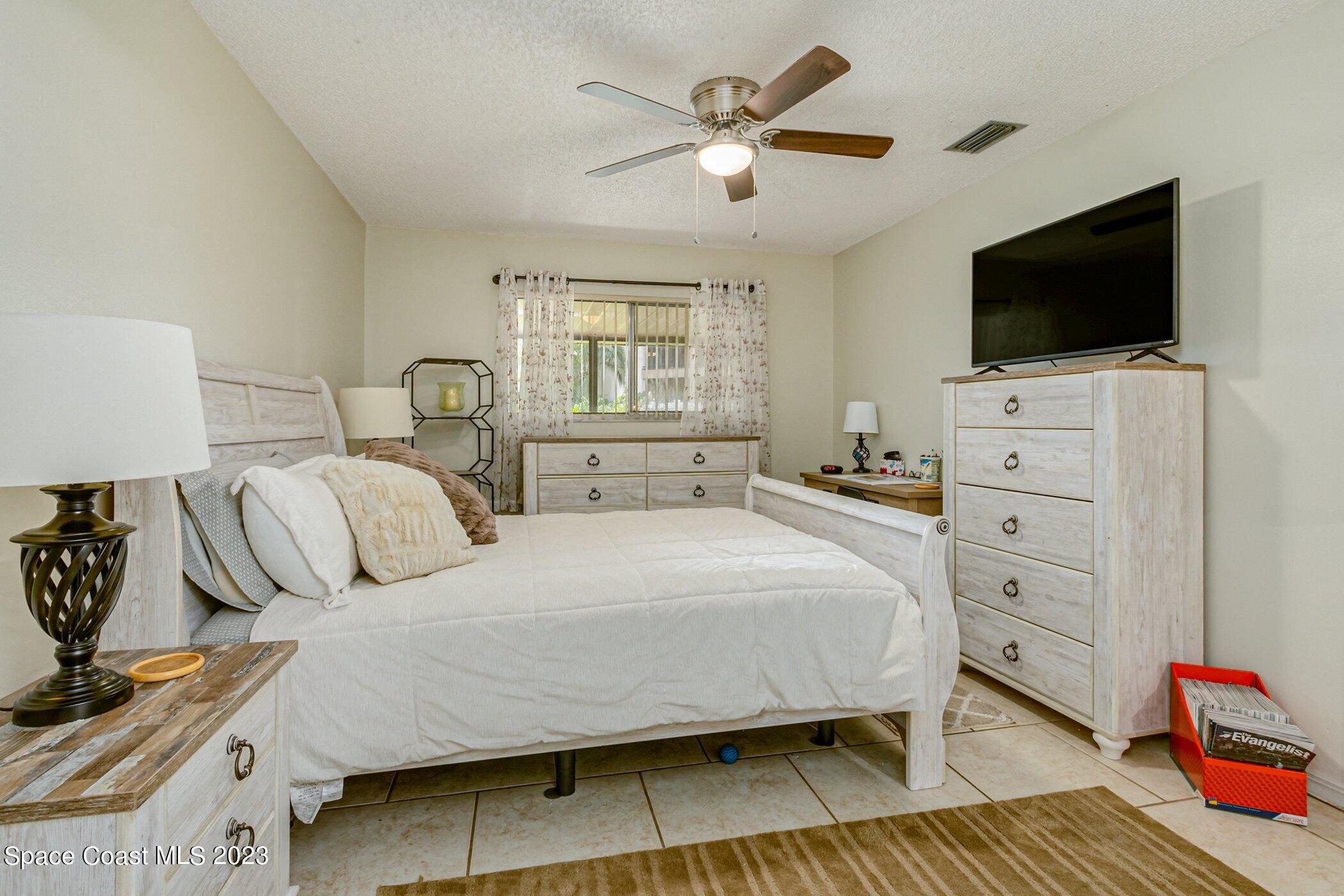 905 Prosperity Place, Unit 1902 Rockledge, FL 32955 - Photo 17 of 35 a bedroom with a bed and a flat screen tv
