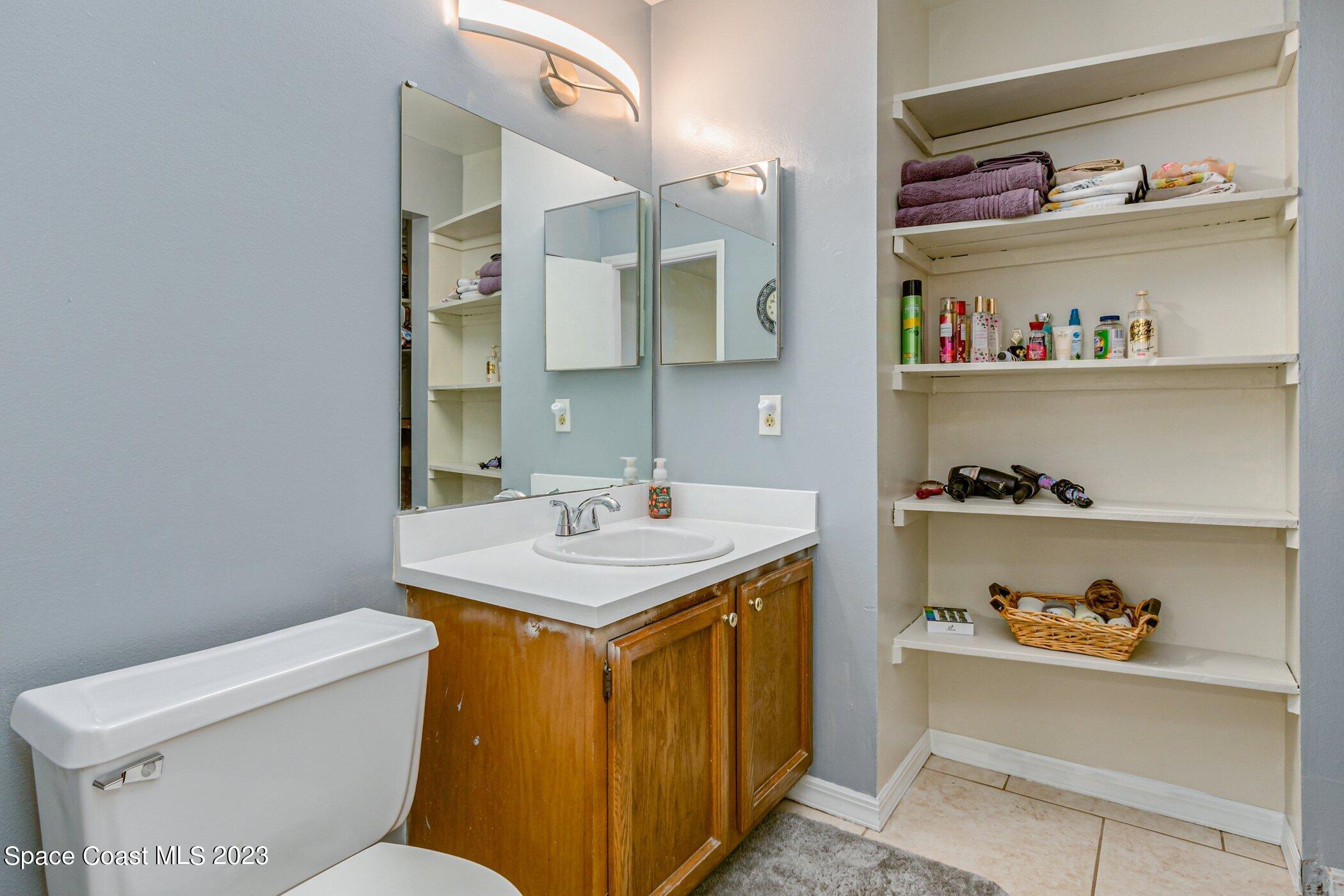 905 Prosperity Place, Unit 1902 Rockledge, FL 32955 - Photo 18 of 35 a bathroom with a sink a toilet and a mirror
