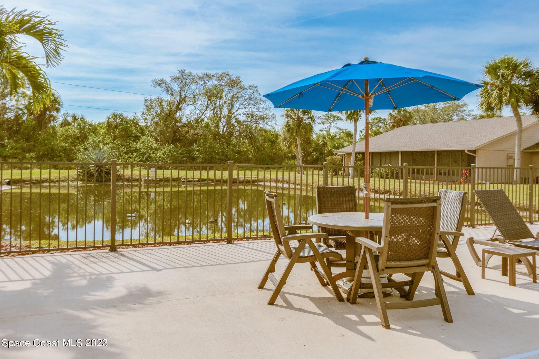 905 Prosperity Place, Unit 1902 Rockledge, FL 32955 - Photo 29 of 35 a view of a lake with table and chairs under an umbrella