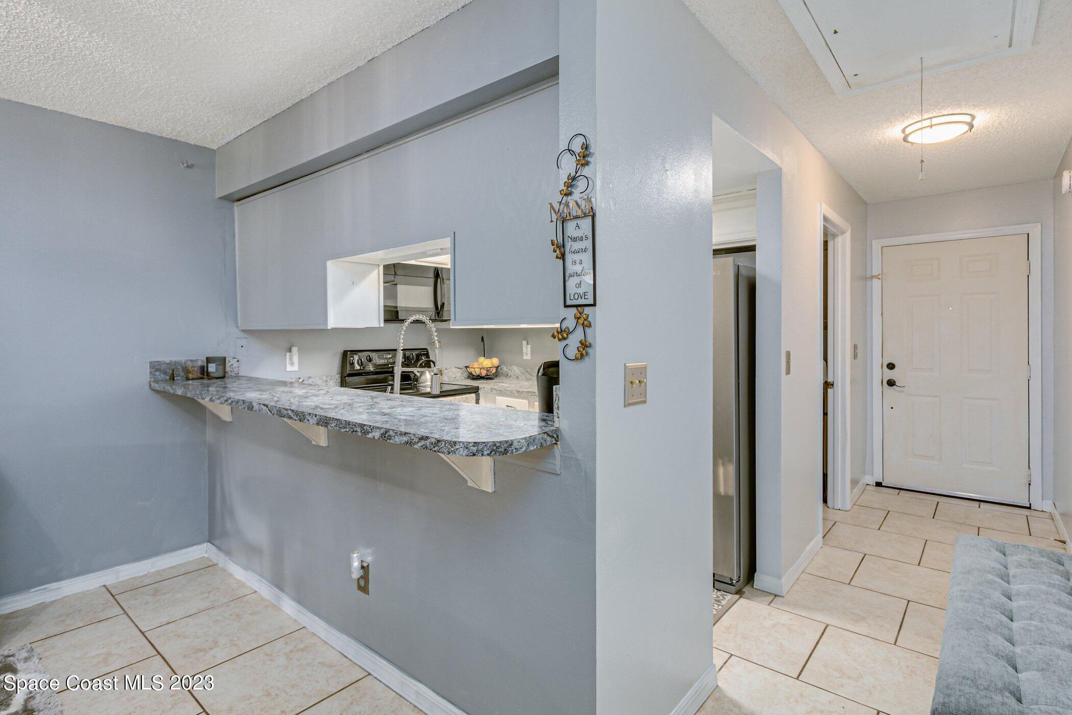 905 Prosperity Place, Unit 1902 Rockledge, FL 32955 - Photo 6 of 35 a kitchen with stainless steel appliances granite countertop a refrigerator and a sink