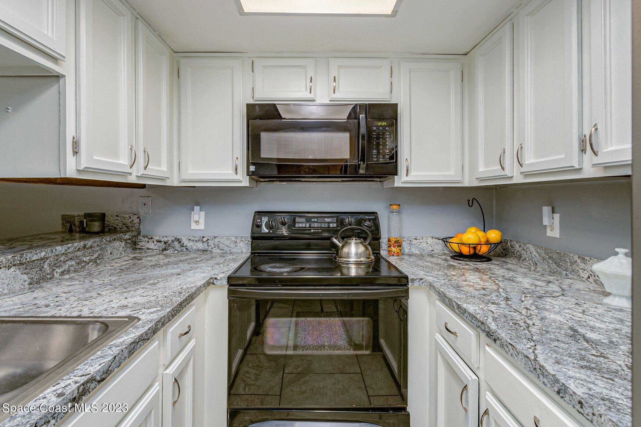 905 Prosperity Place, Unit 1902 Rockledge, FL 32955 - Photo 7 of 35 a kitchen with stainless steel appliances granite countertop a sink stove and cabinets