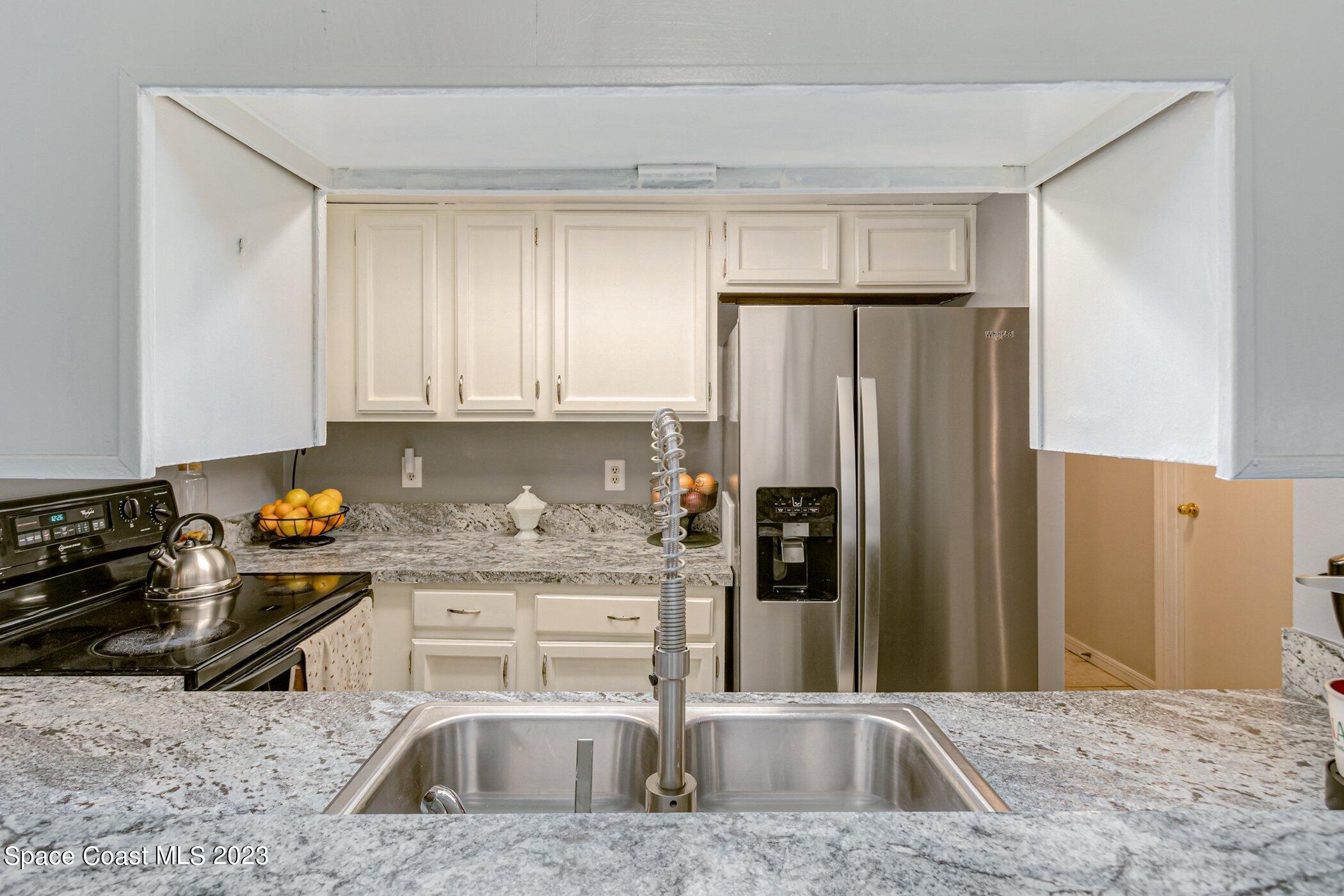 905 Prosperity Place, Unit 1902 Rockledge, FL 32955 - Photo 8 of 35 a kitchen with stainless steel appliances granite countertop a refrigerator sink and stove