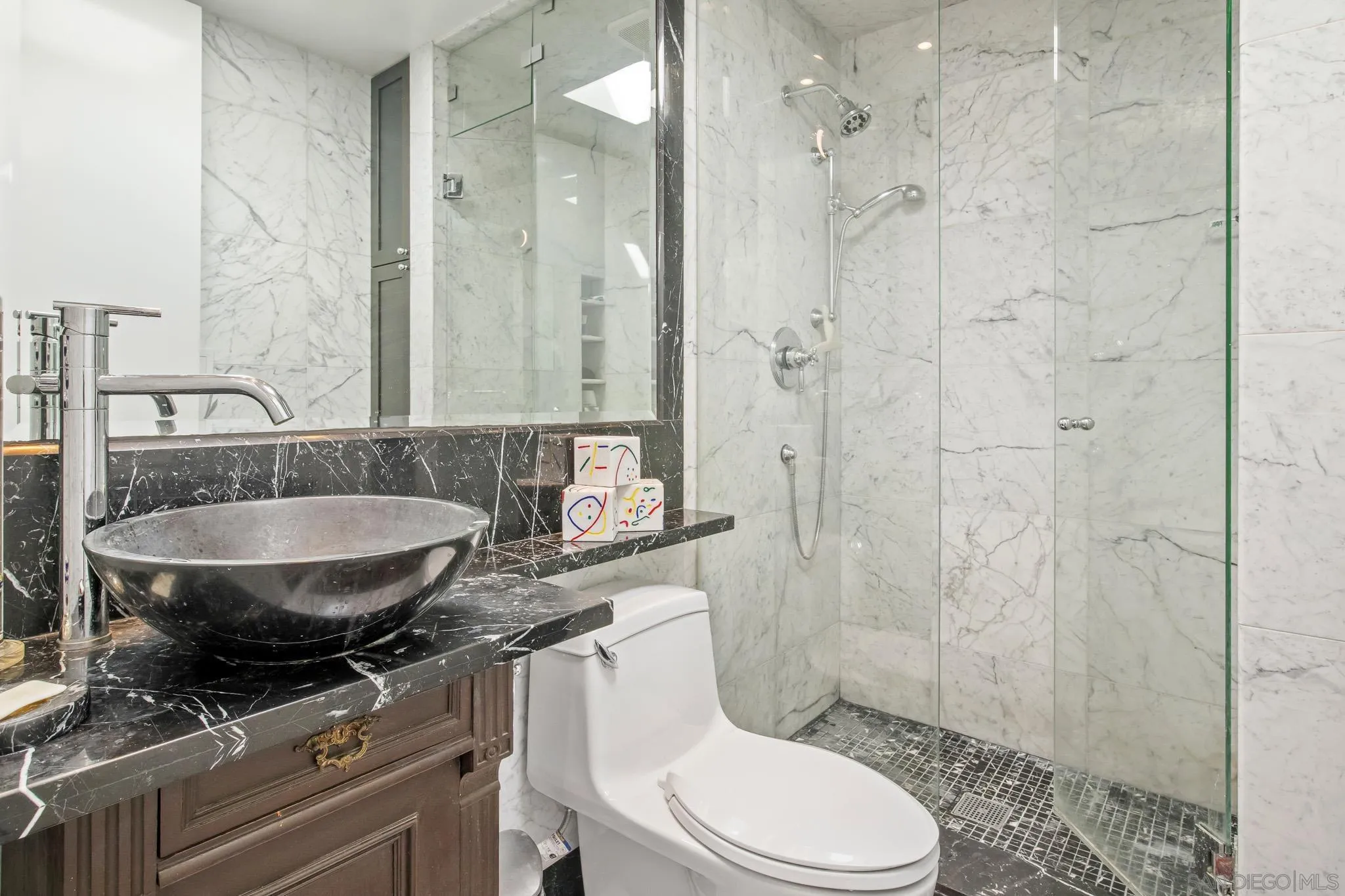 6455 La Jolla Boulevard, Unit 308 La Jolla, CA 92037 - Photo 12 of 18 a bathroom with a granite countertop sink a toilet a mirror and shower