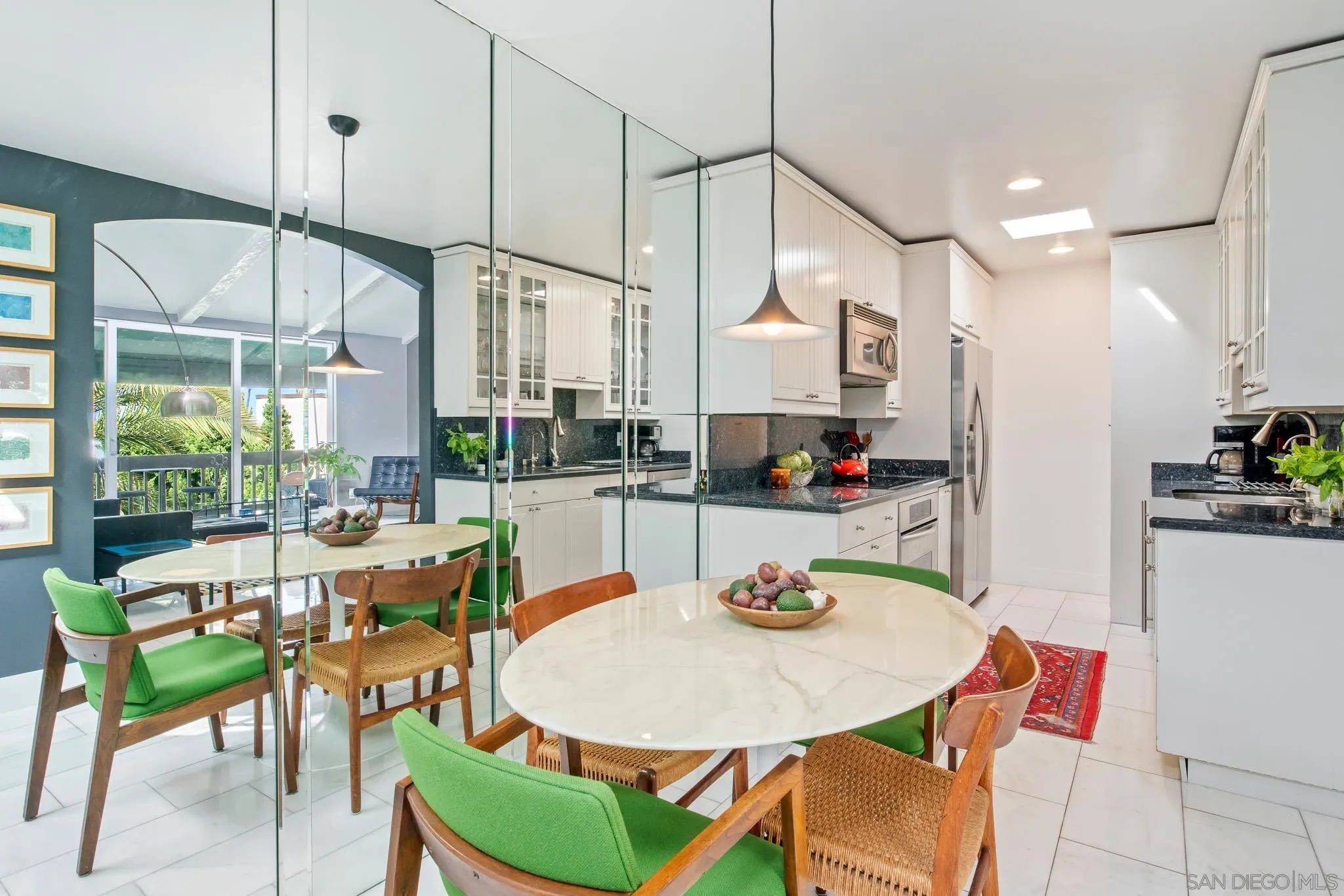 6455 La Jolla Boulevard, Unit 308 La Jolla, CA 92037 - Photo 5 of 18 a kitchen with stainless steel appliances kitchen island granite countertop a dining table chairs and a refrigerator