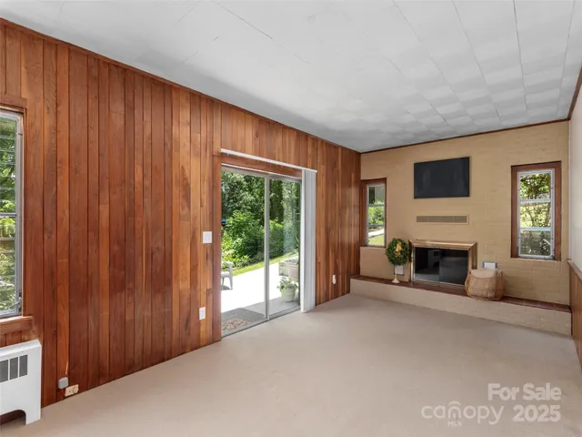 a view of a livingroom with a fireplace window and outdoor space