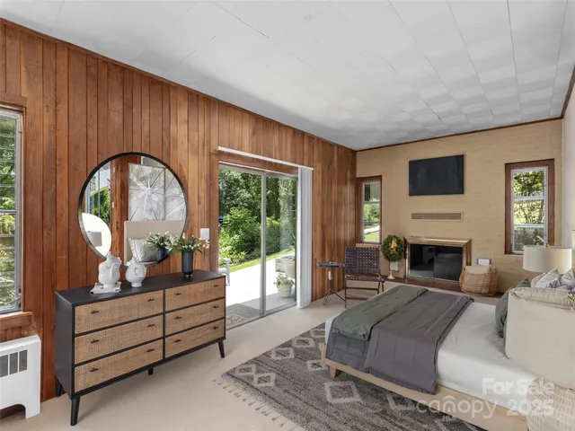 a living room with furniture a fireplace and a large window