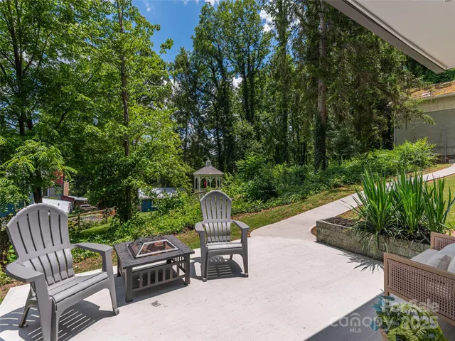 a view of a chair and table in backyard of the house
