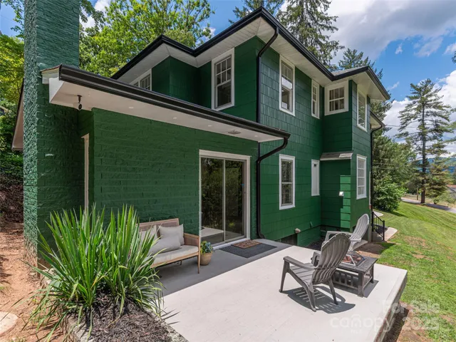 a view of a backyard with potted plants and large trees