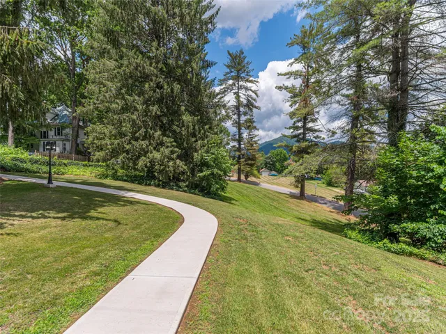 an aerial view of residential houses with outdoor space and trees