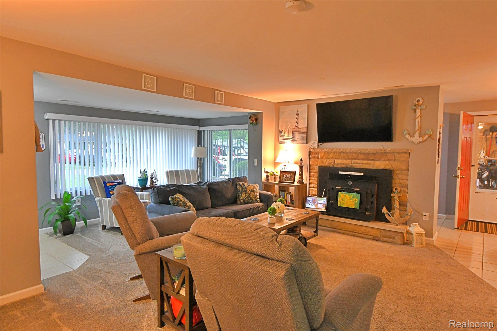 9611 Monroe Road St. Helen, MI 48656 - Photo 8 of 24 Carpeted living area featuring a stone-surround fireplace with an insert