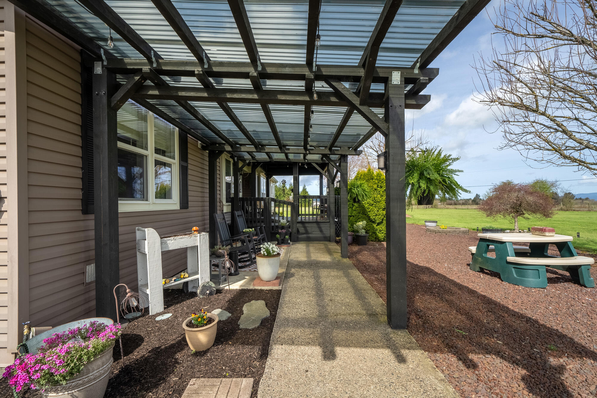7400 South Prairie Road Tillamook, OR 97141 - Photo 26 of 62 a view of a patio with couches table and chairs and potted plants