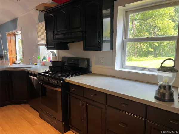 a kitchen with granite countertop a sink a stove and cabinets