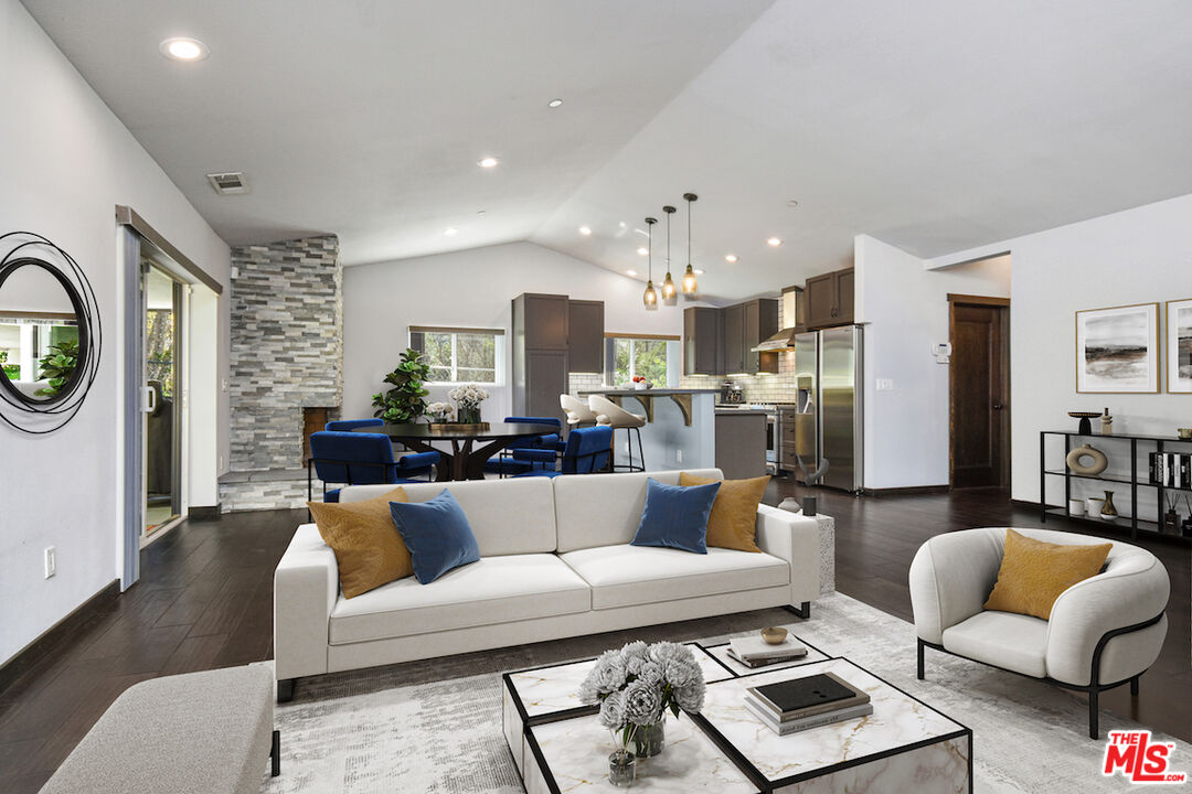 a living room with furniture and a view of kitchen