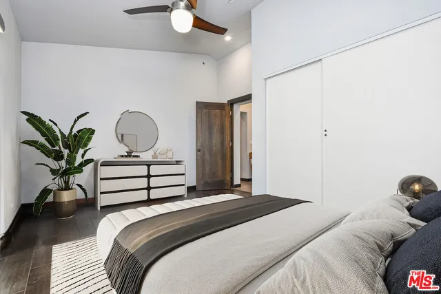 a bedroom with a bed and a potted plant