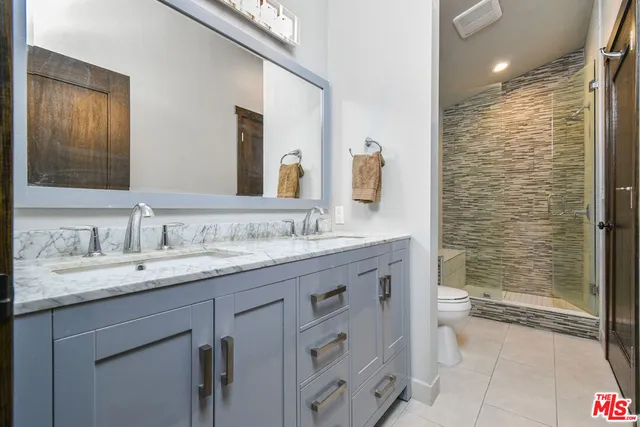a bathroom with a granite countertop sink toilet and shower