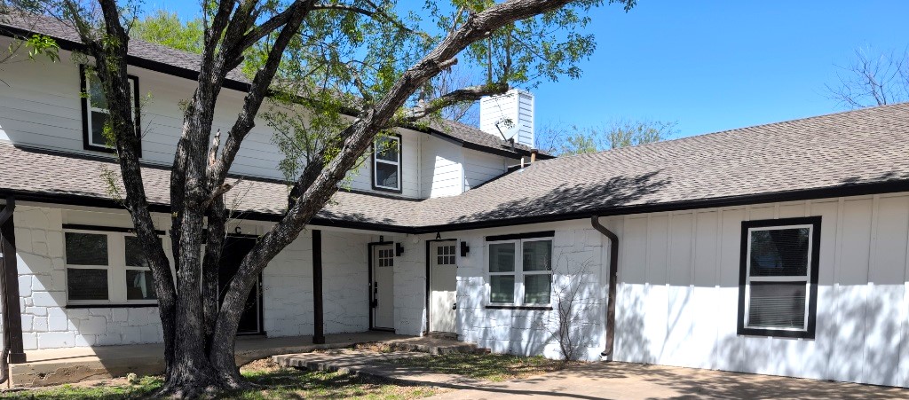 a front view of a house with a tree