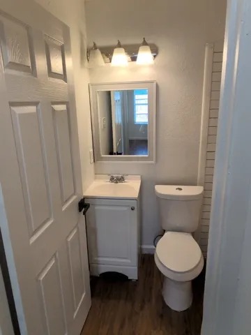 a bathroom with a toilet sink and mirror
