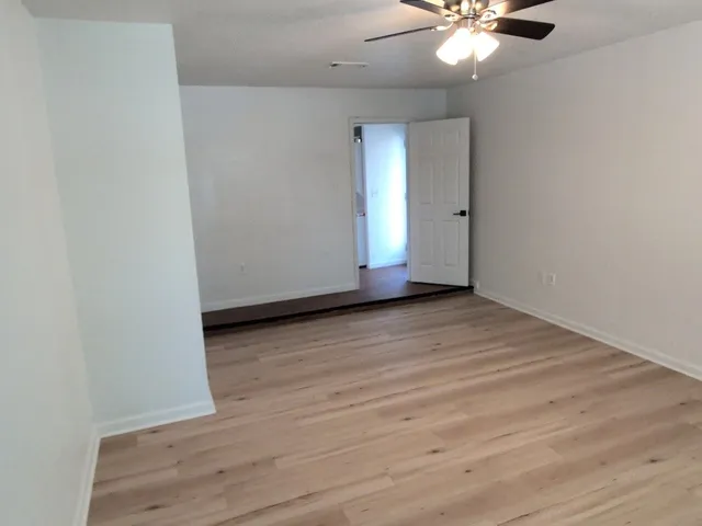 an empty room with wooden floor and windows