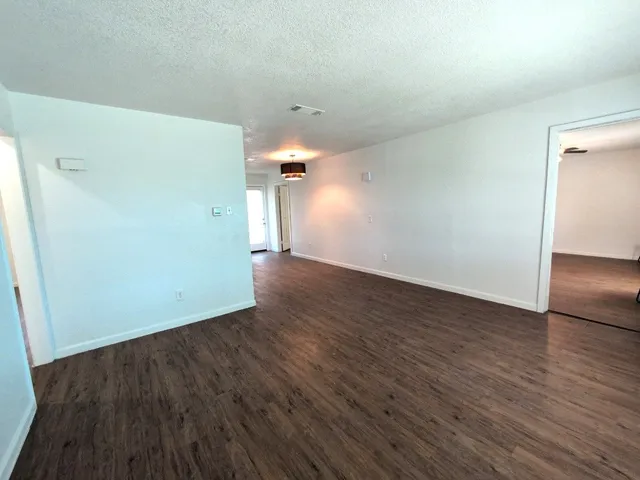 a view of an empty room with wooden floor