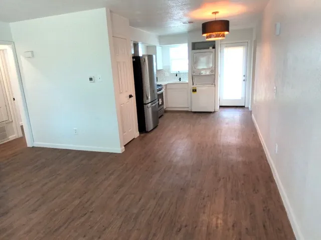 a view of a kitchen with refrigerator and wooden floor