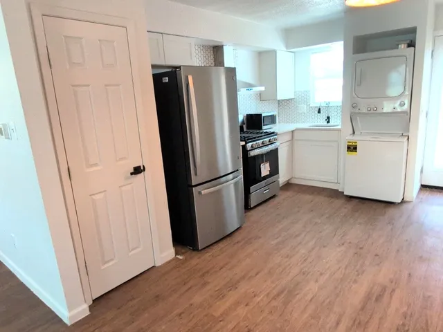 a kitchen with a refrigerator a microwave oven a sink and cabinets