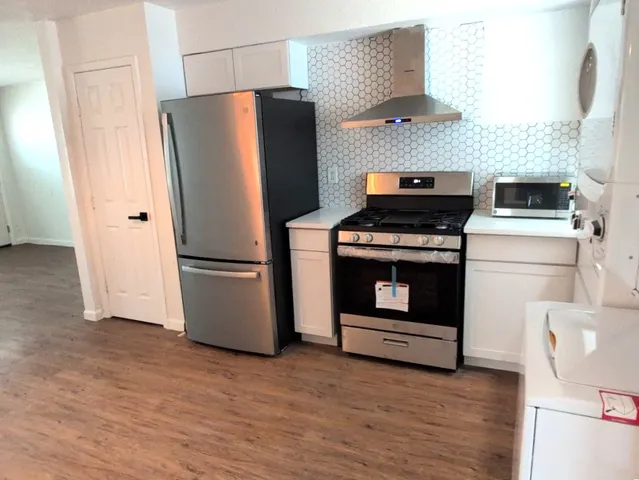 a kitchen with a stove top oven and refrigerator