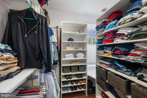 a view of walk in closet with clothes and shoes