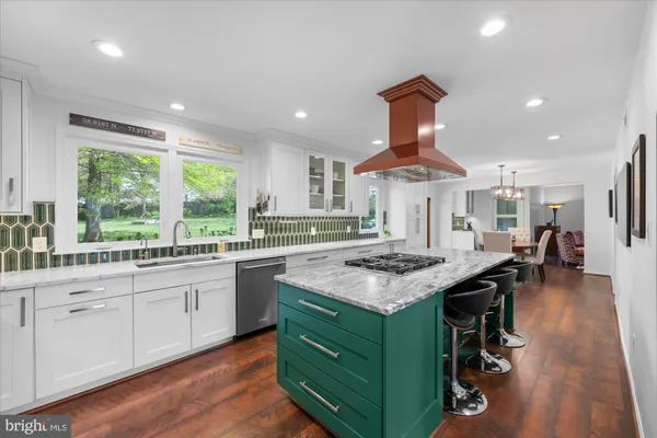 a kitchen with kitchen island a sink stove and a large window