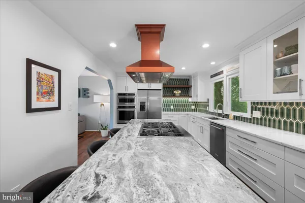 a kitchen with stainless steel appliances kitchen island granite countertop a refrigerator and a stove top oven