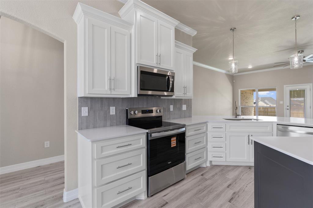 1341 Promised Land Road Hewitt, TX 76643 - Photo 4 of 29 Modern kitchen featuring white shaker cabinetry, stainless steel appliances