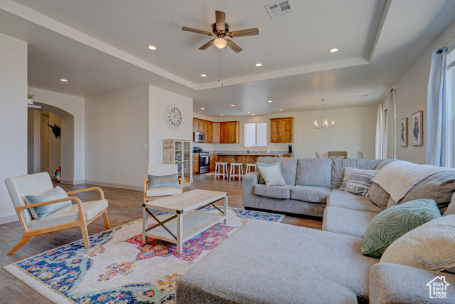 1329 Paseos Street Washington, UT 84780 - Photo 5 of 35 Living room featuring a tray ceiling, recessed lighting, light wood-type flooring, ceiling fan, and a chandelier