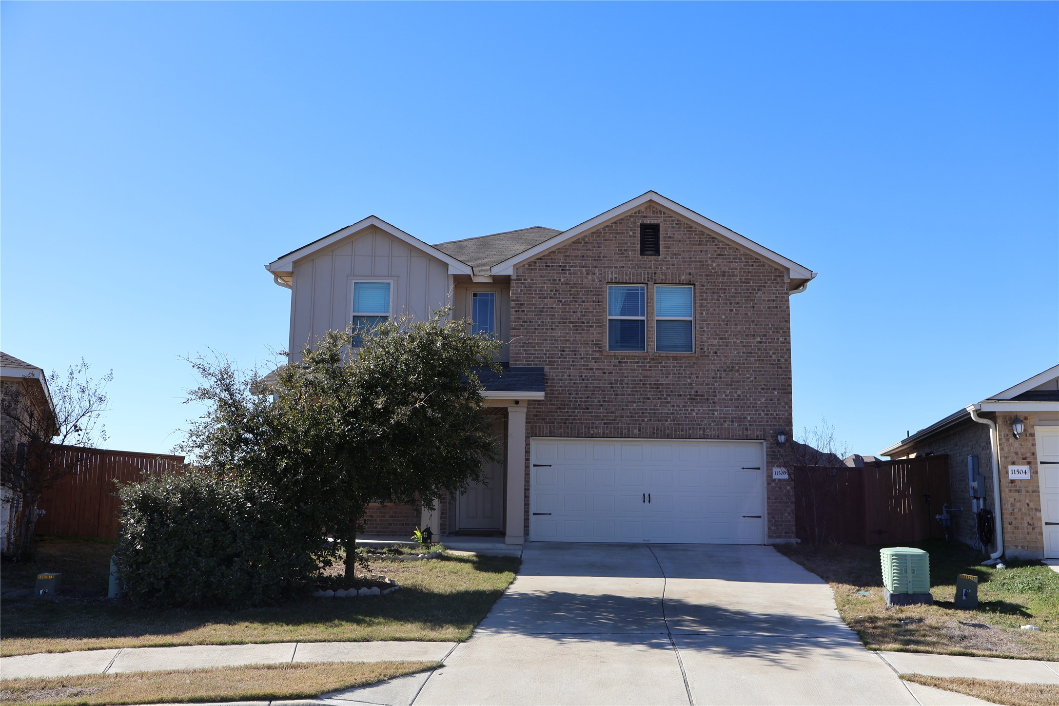 11500 Maple Leaf Way Manor, TX 78653 - Photo 1 of 29 View of front of home with brick siding, driveway, an attached garage, and board and batten siding