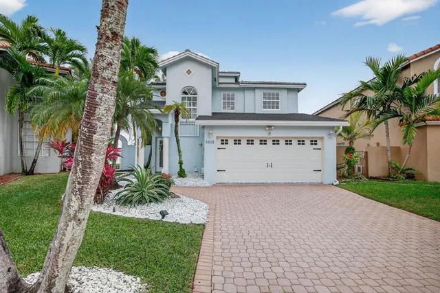 a view of a house with a yard and potted plants