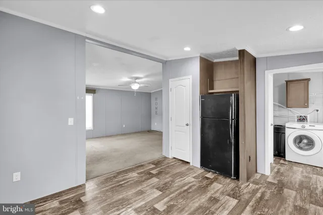 a view of a hallway with a refrigerator and a stove top oven