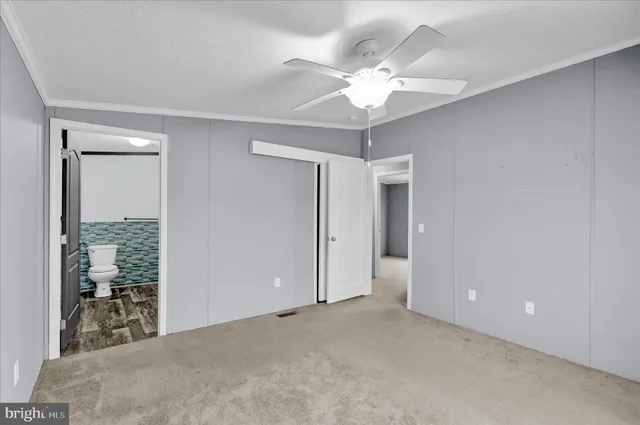 an empty room with fan and entrance