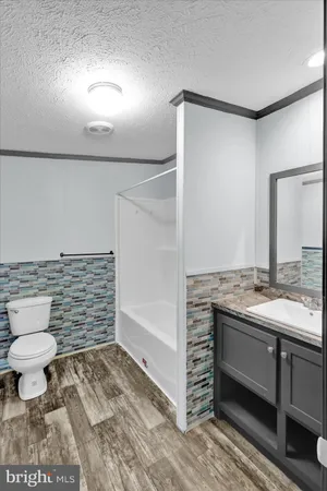 a bathroom with a granite countertop sink a toilet and a mirror