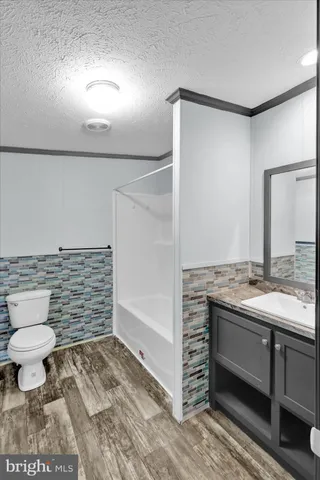 a bathroom with a granite countertop sink a toilet and a mirror
